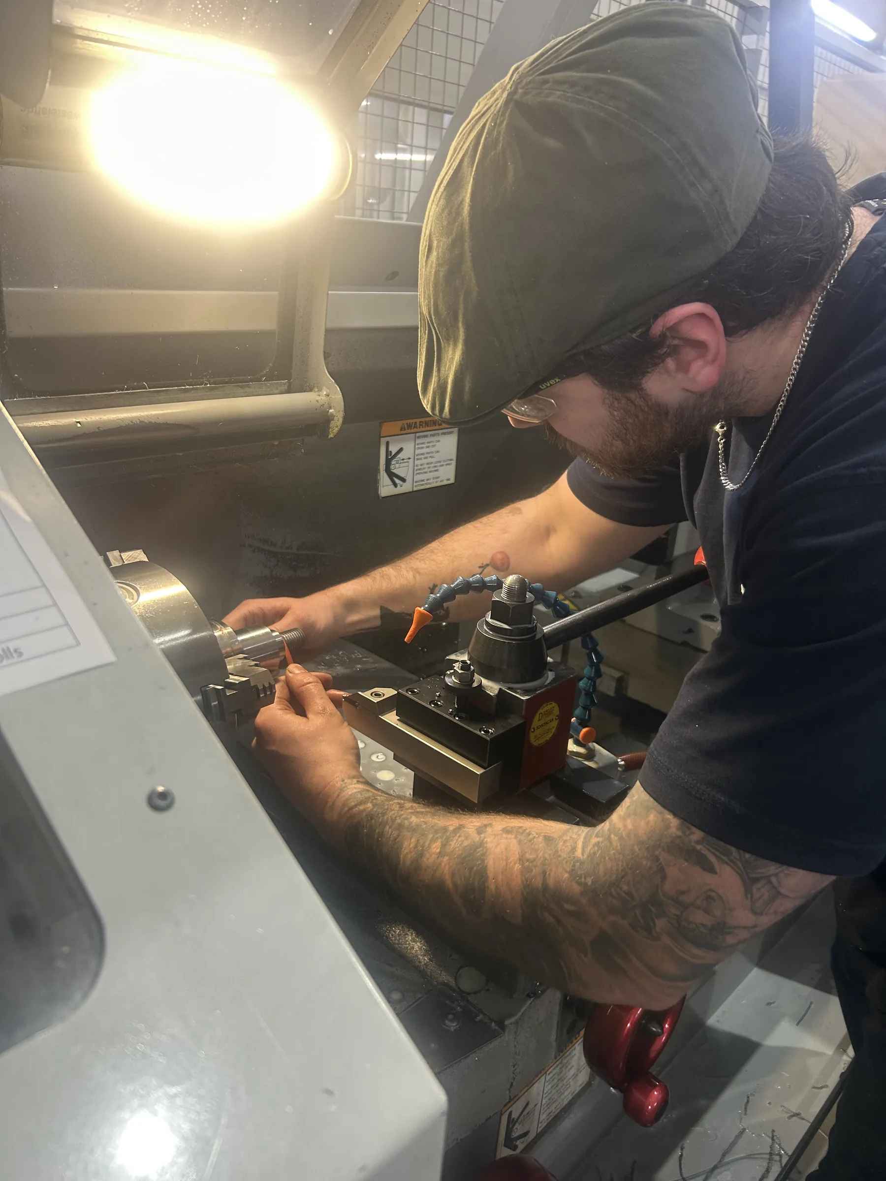Machinist working at a Haas CNC lathe in the Gemini tool room