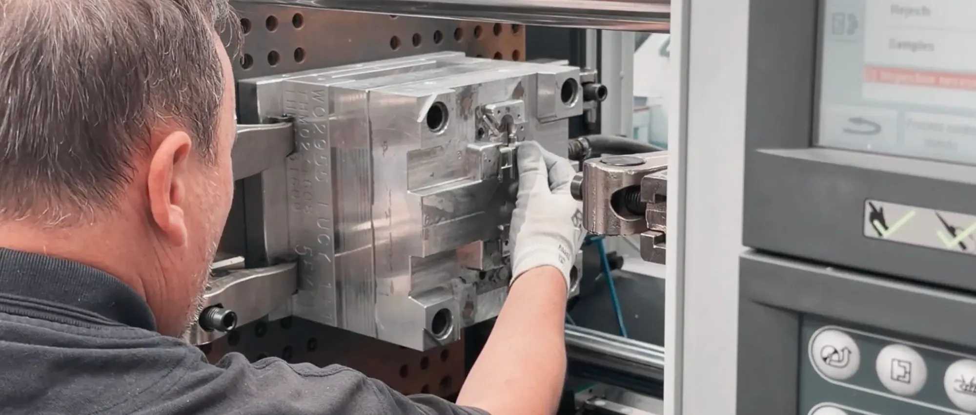 Engineer replacing the mould tool inside an injection moulding machine