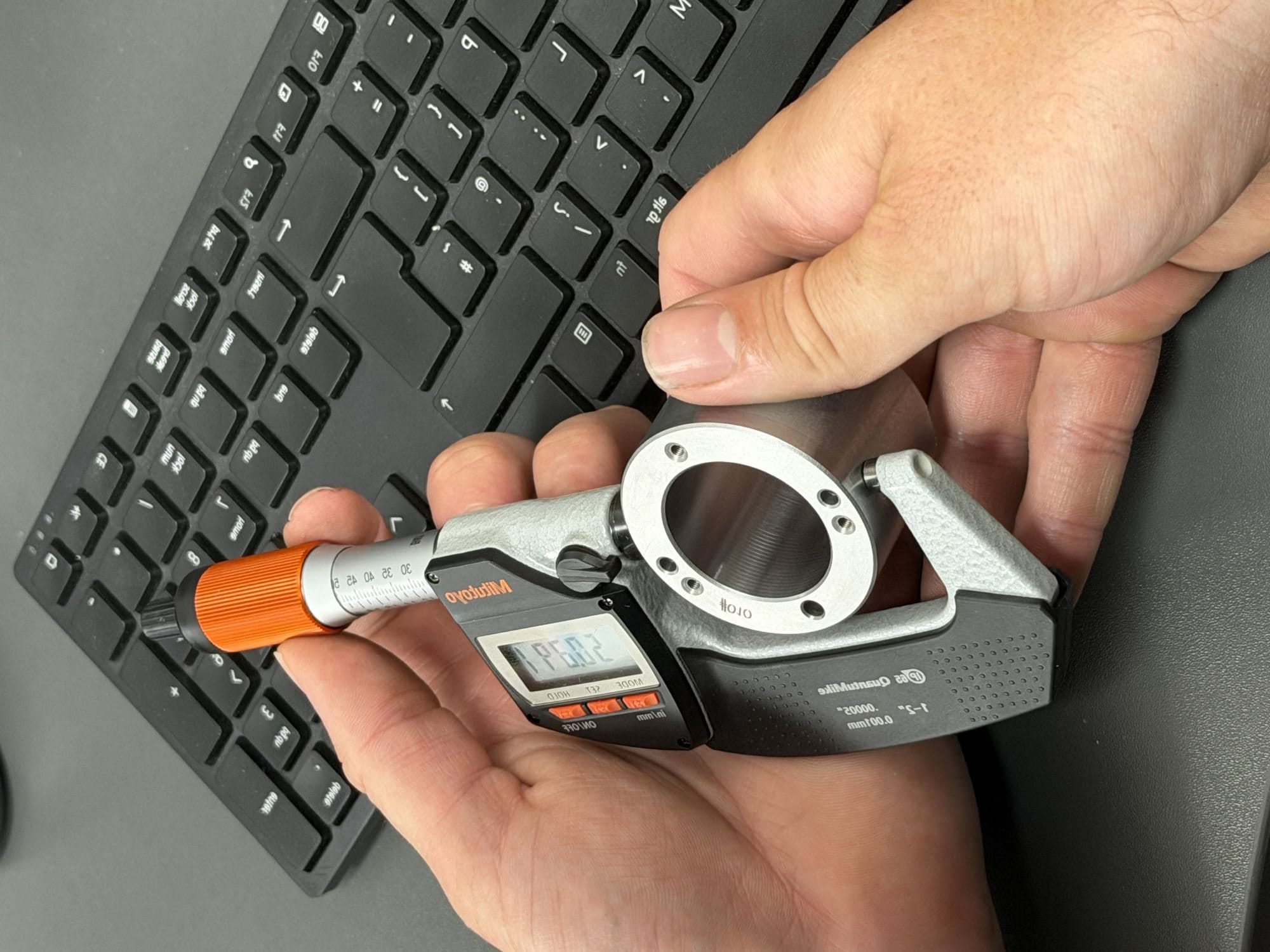 Measuring a machined plastic part with a micrometer at Gemini